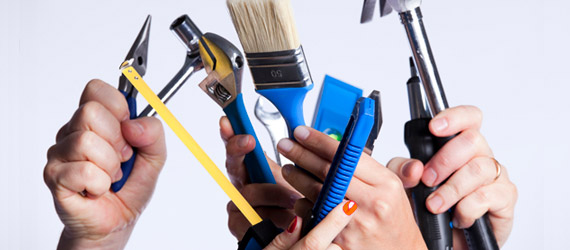 hands holding up tools, paintbrushes, and more