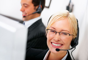 smiling call center agent with headset sitting next to man