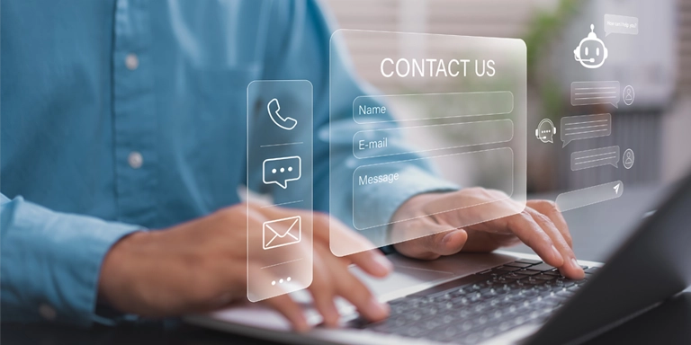 Man in blue shirt working from a computer with overlay of contact us screen and phone, chat and email icons