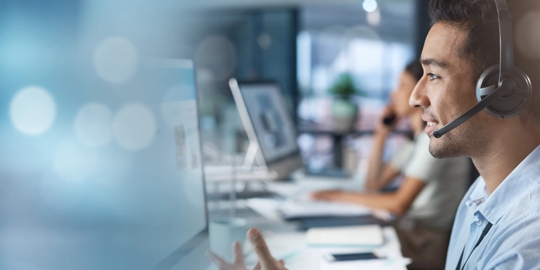 man in headset looking into a computer screen that's blurred into a blue graphic