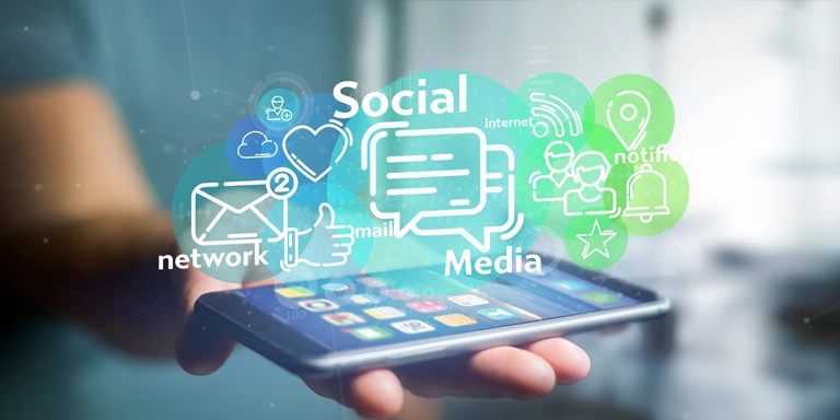 La mano sostiene un teléfono con la palma abierta, con las imágenes de las redes sociales flotando encima.