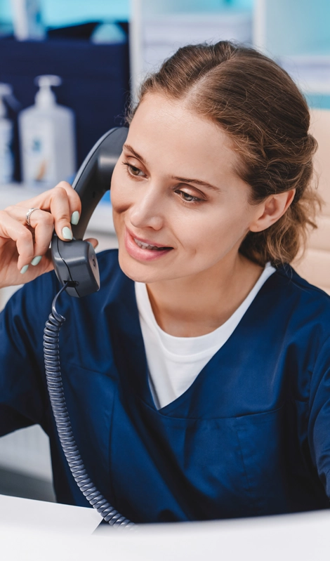 Woman wearing scrubs talking on a phone