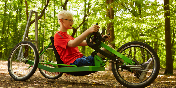 Un garçon avec une jambe sur un vélo
