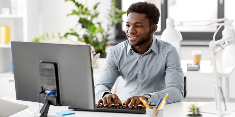 Man with beard at a desk working at a computer